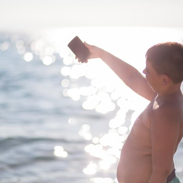 boy on the beach making selfie