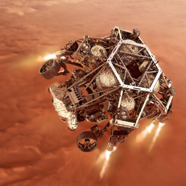 Der Mars-Rover „Perseverance“ schwebt über der roten Marsoberfläche.
