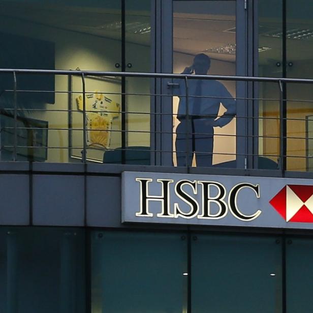 A man uses a mobile phone in a branch of HSBC in St Helier, Jersey November 12, 2012. HSBC, Europe&#039;s biggest bank, is at the centre of an investigation by British tax authorities into leaked data that a newspaper said showed it provided accounts in the tax haven of Jersey for alleged criminals. REUTERS/Stefan Wermuth (JERSEY - Tags: BUSINESS)