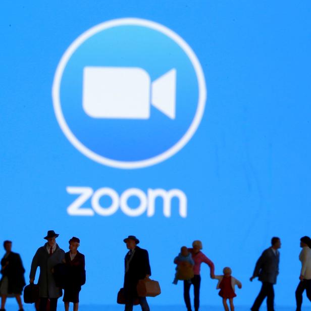 FILE PHOTO: Small toy figures are seen in front of diplayed Zoom logo