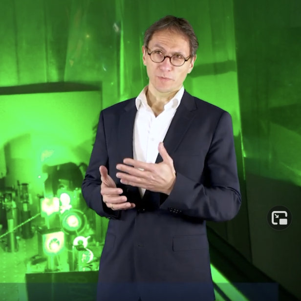 Markus Arndt vor einem grün beleuchteten Labor der Österreichischen Akademie der Wissenschaften.