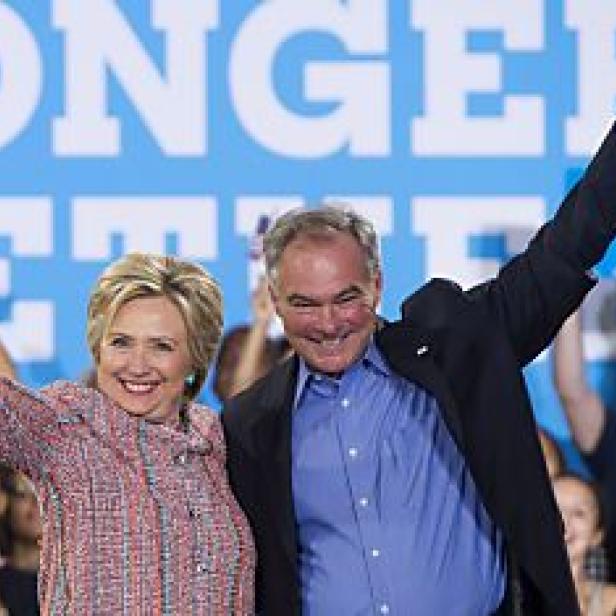 Hillary Clinton und Tim Kaine stehen mit erhobenen Armen vor einer jubelnden Menge.