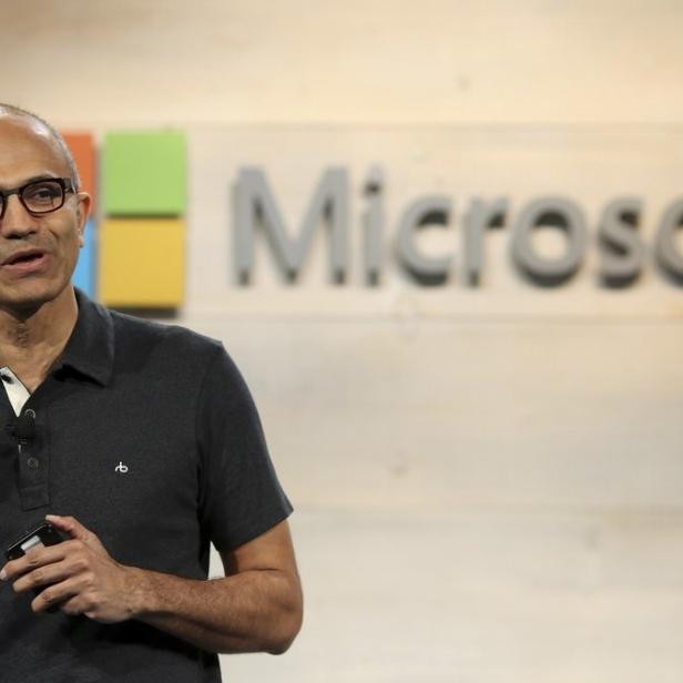 Satya Nadella, der CEO von Microsoft, hält eine Präsentation vor dem Microsoft-Logo.