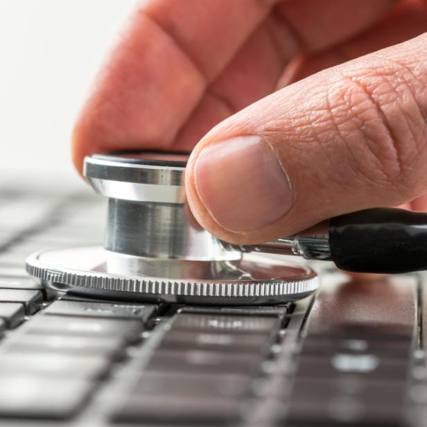 Ein Stethoskop wird auf eine Computertastatur gelegt.