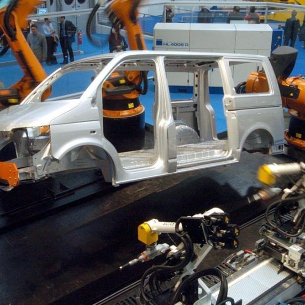 Roboter simulieren am Montag (19.04.2004) auf der Hannover Messe Industrie in der niedersächsischen Landeshauptstadt an einer VW T5-Karosserie verschiedene Schweißarbeitsgänge. Die weltgrößte Industrieschau soll wichtige Impulse für den erhofften Konjunkturaufschwung in Deutschland geben. Bis kommenden Samstag zeigen rund 5.000 Aussteller Produkte und Lösungen rund um die Fertigungs- und Prozessindustrie. Die Zahl der Aussteller ist wegen der schwachen Konjunktur und der Auslagerung von Einzelmessen gesunken. Foto: Kay Nietfeld dpa/lni