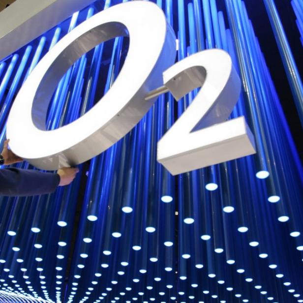 File photo of a worker making final touches to the logo of mobile phone company O2 in preparation for the CeBIT computer fair in the northern German town of Hanover March 6, 2006. Dutch telecoms group KPN announced on July 23, 2013 that will sell its German unit to Telefonica Deutschland O2 for some 8.1 billion euros ($11 billion) in cash and shares, in a long-awaited deal that will test regulators&#039; views in Europe&#039;s largest mobile market. If KPN&#039;s disposal of E-Plus is finalised, the new company would hold a share of about 30 percent of Germany&#039;s mobile service revenue and would be better armed to take on Deutsche Telekom and Vodafone, with 35 percent each. REUTERS/Christian Charisius/files (GERMANY - Tags: SCIENCE TECHNOLOGY BUSINESS TELECOMS)