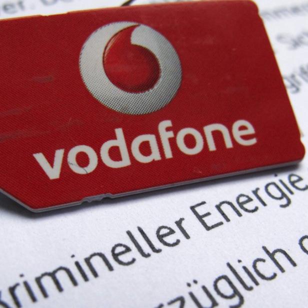 A SIM card of Vodafone is pictured in front of a letter of Vodafone Germany in Dortmund September 12, 2013. A hacker has gained access to one of Vodafone Germany&#039;s servers and has stolen the personal data of about 2 million customers, the company said on Thursday. REUTERS/Ina Fassbender (GERMANY - Tags: BUSINESS TELECOMS CRIME LAW LOGO)