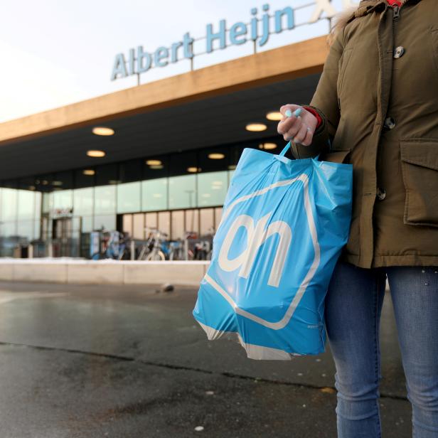FILE PHOTO: A woman holds a bag with the logo of Albert Heijn, operated by Ahold Delhaize, the Dutch-Belgian supermarket operator, in Eindhoven