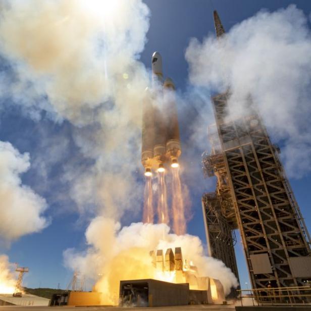 Eine Rakete startet mit viel Rauch und Flammen von einer Startrampe.