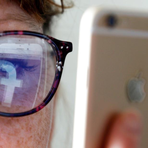 FILE PHOTO: The Facebook logo is reflected on a woman's glasses in this photo illustration