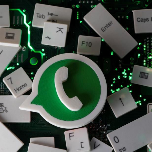 A 3D printed Whatsapp logo and keyboard buttons are placed on a computer motherboard