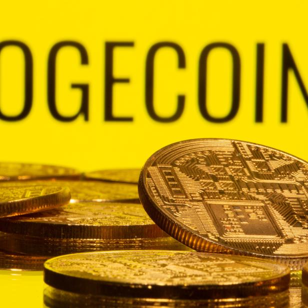 Cryptocurrency representations are seen in front of the Dogecoin logo in this illustration