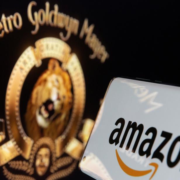 Smartphone with Amazon logo is seen in front of displayed MGM logo in this illustration taken