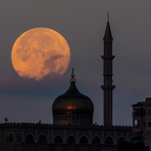 A super moon, known as the "Super Flower Moon", rises over the Nabi Sain Mosque in Nazareth