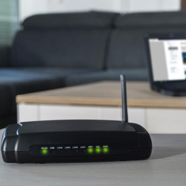 WLAN-Router mit Laptop im Hintergrund