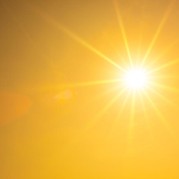 Hot summer or heat wave background, orange sky with glowing sun