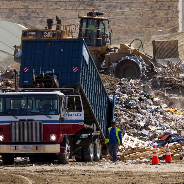 Workers use heavy machinery to move trash and waste at the Frank R. Bowerman landfill in California