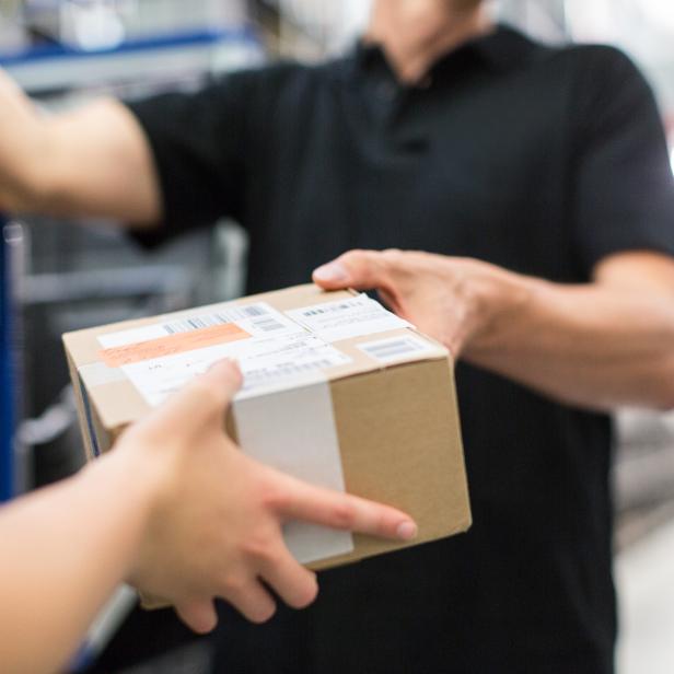 Worker handing over a package to colleague