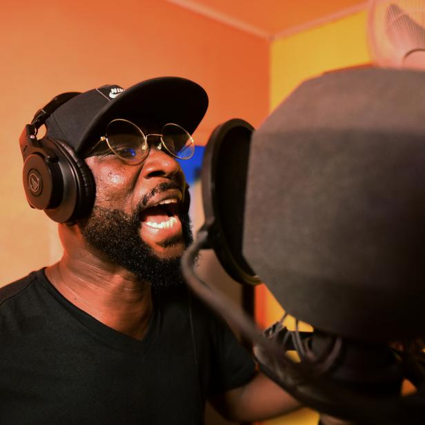 Sierra Leonean musician Emmerson Bockarie sings into a microphone while recording a song at a studio in Freetown,