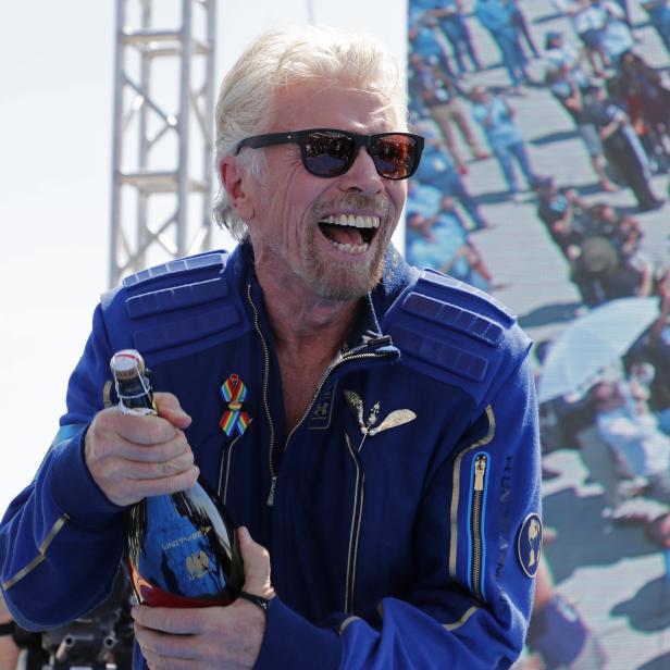 Billionaire entrepreneur Richard Branson prepares to spray champagne at Spaceport America