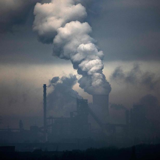 Rauch steigt aus den Schornsteinen einer Industrieanlage auf.