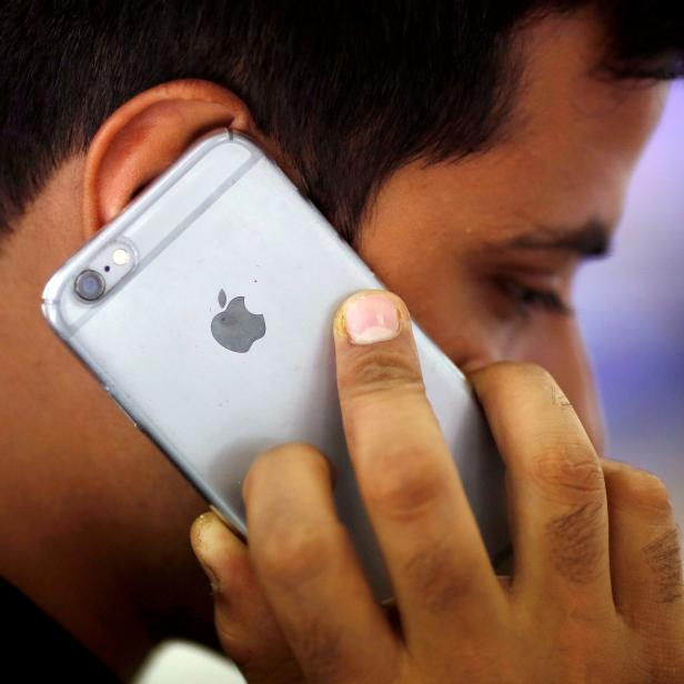 FILE PHOTO: A man talks on his iPhone at a mobile phone store in New Delhi