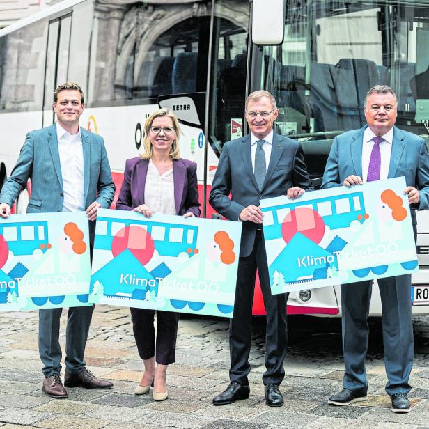 Vier Personen präsentieren das KlimaTicket OÖ vor einem Bus.