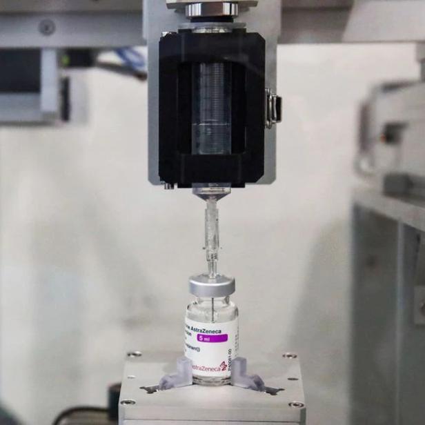 Eine Maschine befüllt eine Ampulle des AstraZeneca-Impfstoffs.