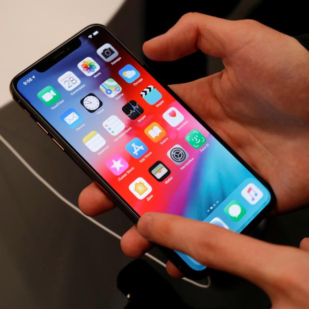 FILE PHOTO: A customer tests a smartphone during the launch of the new iPhone XS and XS Max sales at a shop in Moscow