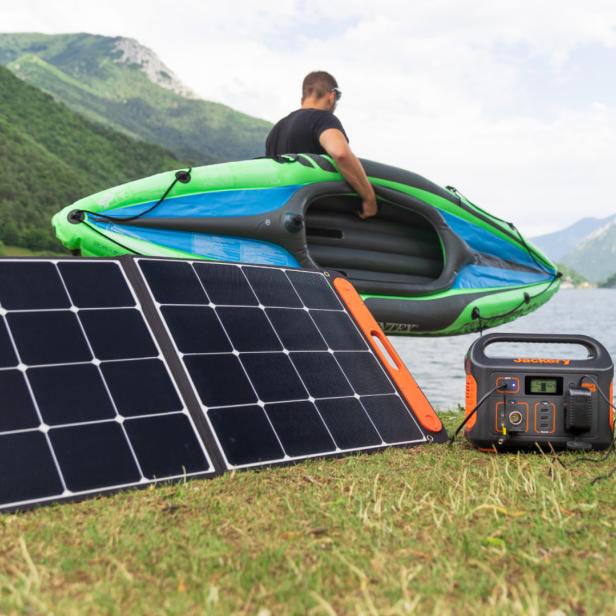 Jackery Explorer 500 und Solarpaneel vor Bergsee mit Kanufahrer