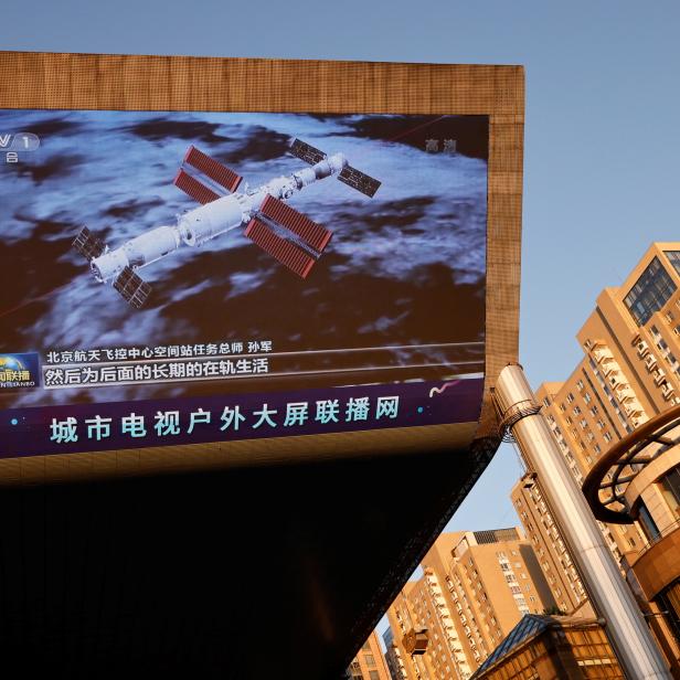 Ein riesiger Bildschirm zeigt ein Bild des bemannten Raumschiffs Shenzhou-12, das erfolgreich an das Tianhe-Kernmodul der chinesischen Raumstation angedockt hat, in einem Einkaufszentrum in Peking.