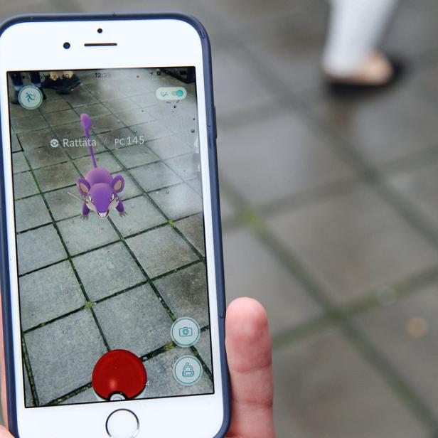 Ein Rattfratz erscheint auf dem Bildschirm eines Smartphones während des Pokémon Go Spiels.