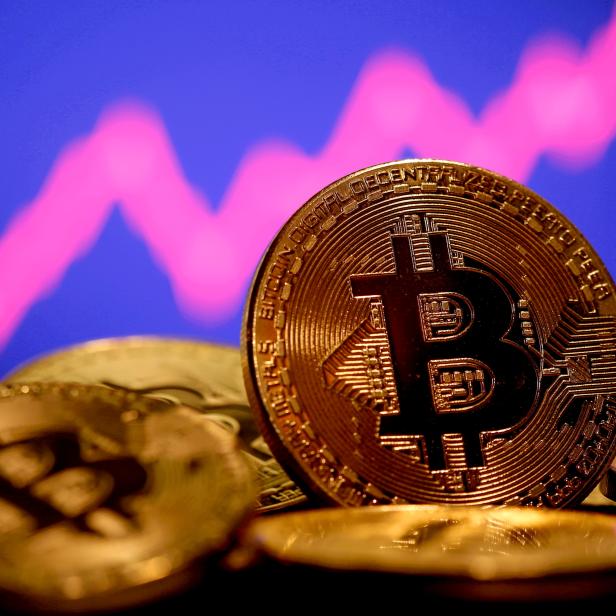 FILE PHOTO: A representation of virtual currency Bitcoin is seen in front of a stock graph in this illustration taken