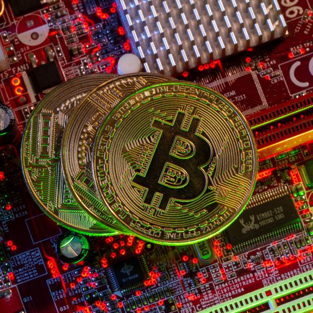 Representations of the virtual currency Bitcoin stand on a motherboard in this picture illustration