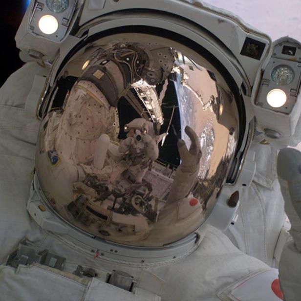 Ein Astronaut im Raumanzug mit Blick auf die Erde im Hintergrund.