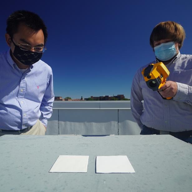 Forscher der Purdue University mit Messgerät und zwei Proben mit weißer Farbe