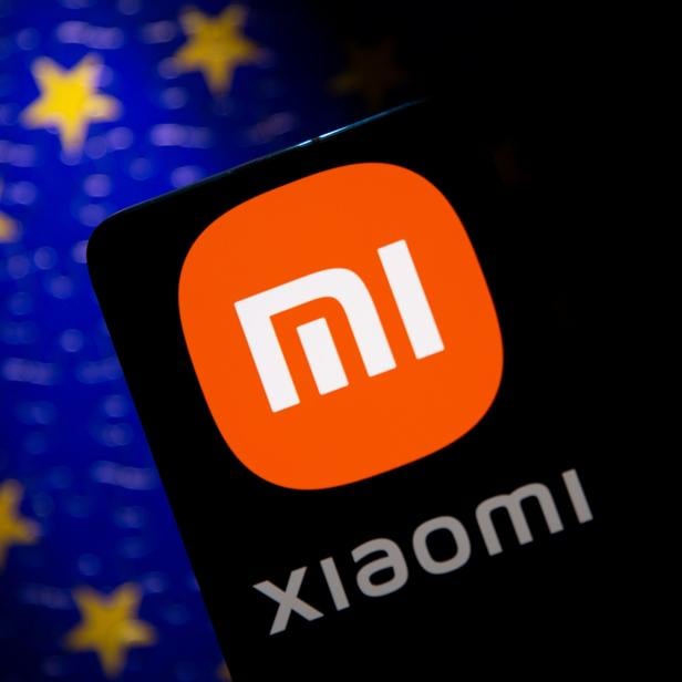 Smartphone with a Xiaomi logo is seen in front of E.U. flag in this illustration