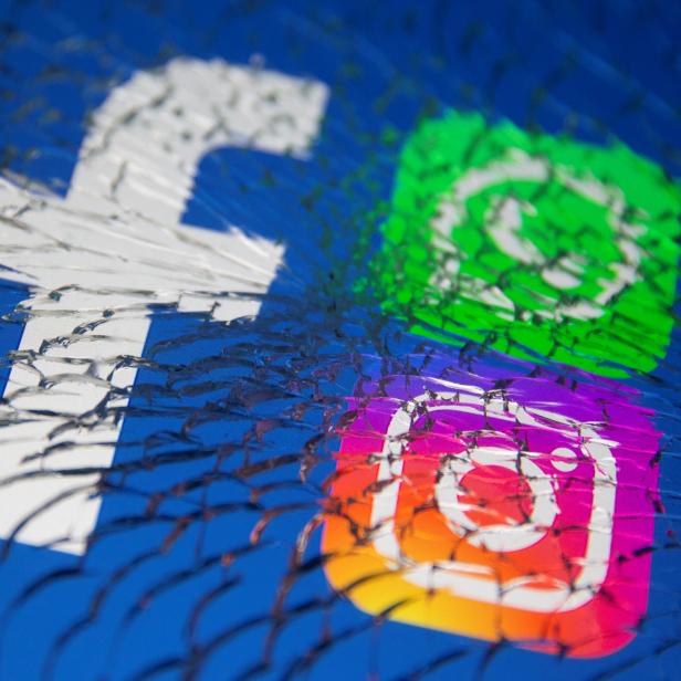 Facebook, Whatsapp and Instagram logos are displayed through broken glass in this illustration