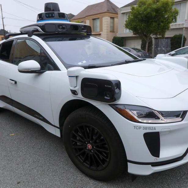 A Waymo Jaguar I-Pace SUV is seen driving on a road in San Francisco