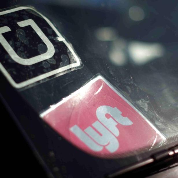Die Windschutzscheibe eines Autos zeigt Aufkleber von Uber und Lyft.