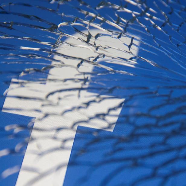 FILE PHOTO: Facebook logo is displayed through broken glass in this illustration