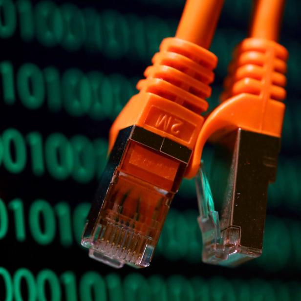 Zwei orangefarbene Netzwerkkabel vor einem Hintergrund aus binärem Code.