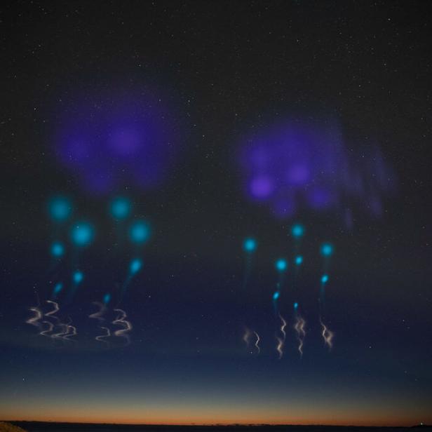 Blaue Jets und Elfen leuchten am Nachthimmel.