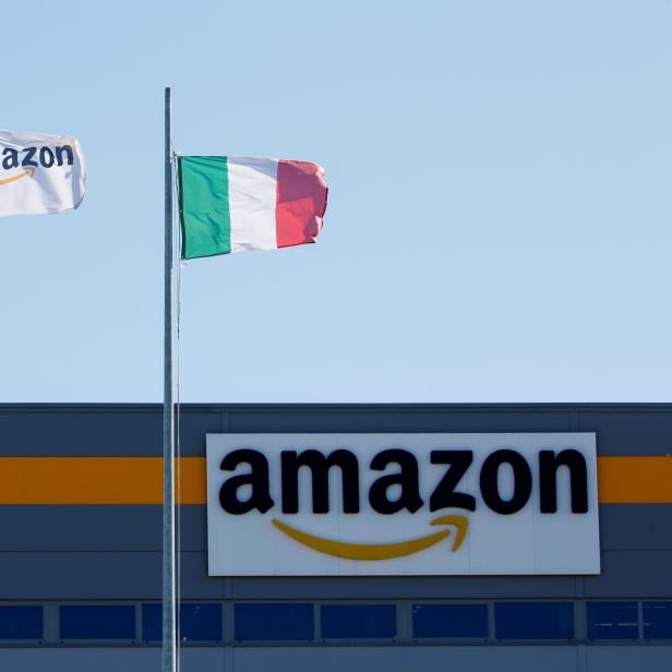 FILE PHOTO: Flags flutter outside a distribution centre, during a strike at Amazon's logistics operations in Italy, in Passo Corese, Italy