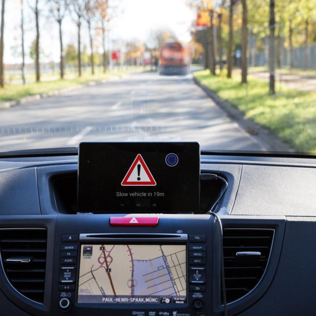 Aus dem Cockpit eines Autos wird vor einem langsamen Fahrzeug in 19 Metern Entfernung gewarnt.