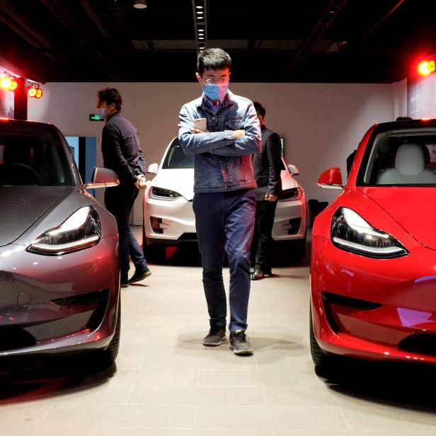 FILE PHOTO: FILE PHOTO: FILE PHOTO: FILE PHOTO: FILE PHOTO: Man walks by Tesla Model 3 sedans and Tesla Model X sport utility vehicle at a new Tesla showroom in Shanghai