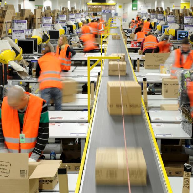 ARCHIV - Mitarbeiter der Versandabteilung des Amazon Logistik-Zentrums in Pforzheim (Baden-Württemberg), verpacken am 11.12.2012 Waren in Pakete (Aufnahme mit Langzeitbelichtung). Der Einzelhandel unterliegt einem ständigen Wandel. Durch den Boom des Online-Handels sind die stationären Händler noch mehr gefordert, ihren Laden am Laufen zu halten. Foto: Jan-Philipp Strobel/dpa (zu dpa «Einzelhandelsverband: Online-Handel bedroht Innenstädte nicht» vom 12.02.2013) +++(c) dpa - Bildfunk+++