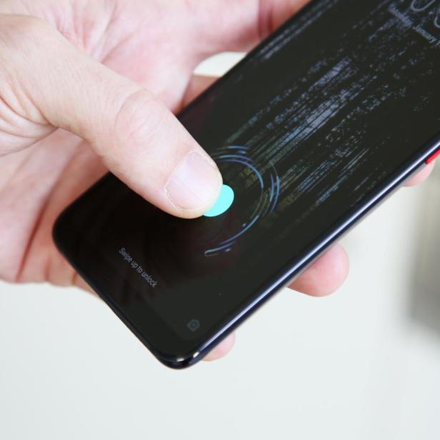 Ein Finger entsperrt ein Smartphone mit Fingerabdrucksensor.