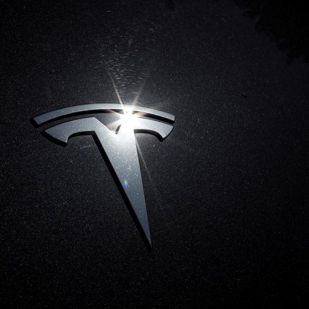 FILE PHOTO: The Tesla logo is seen on a car in Los Angeles