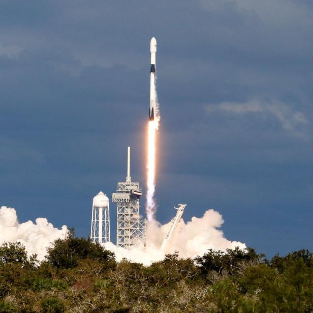 Eine Rakete startet mit einer Rauchwolke in den Himmel.